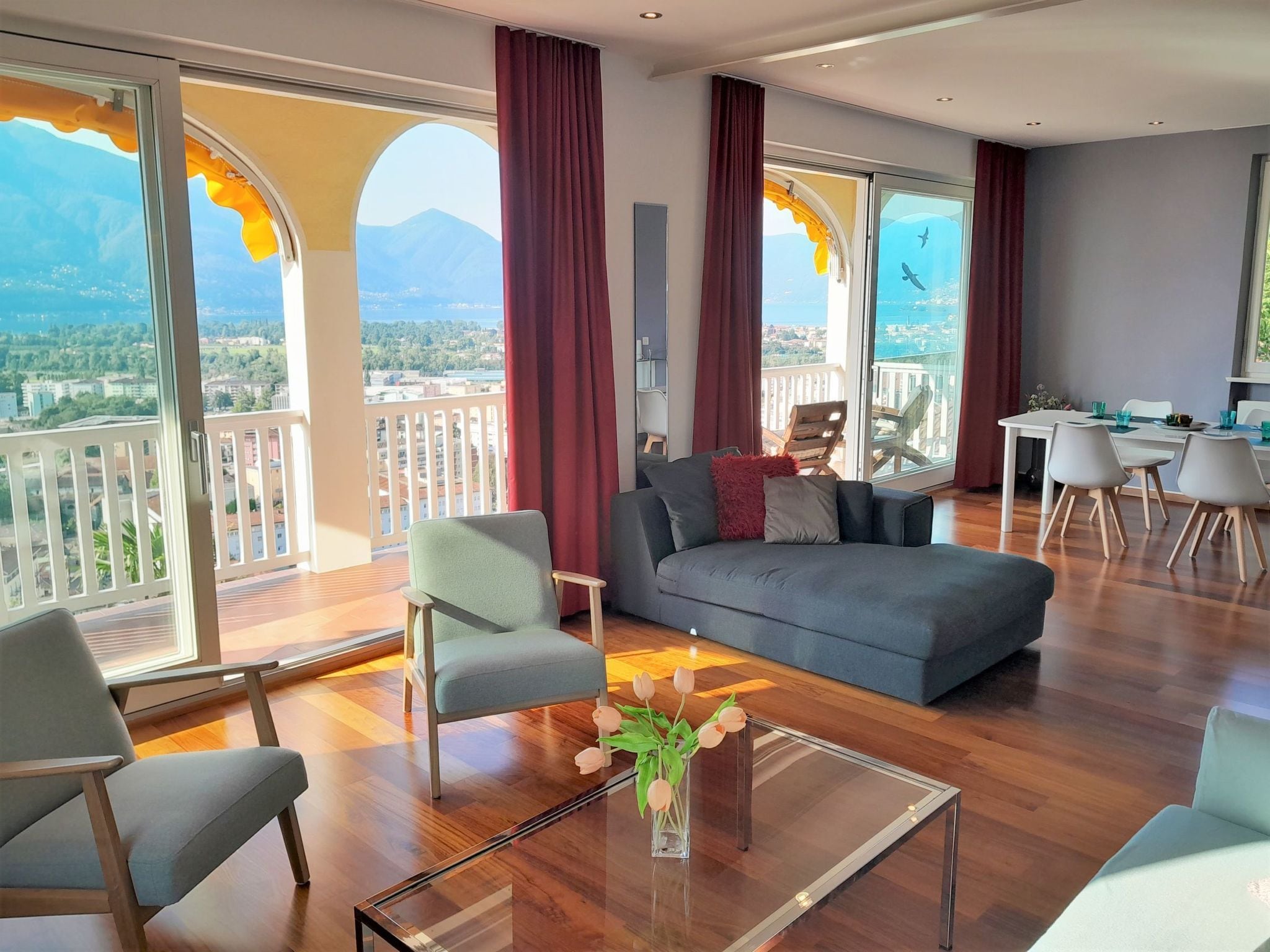 Un salon spacieux avec un balcon, un canapé, une table basse et un coin repas.