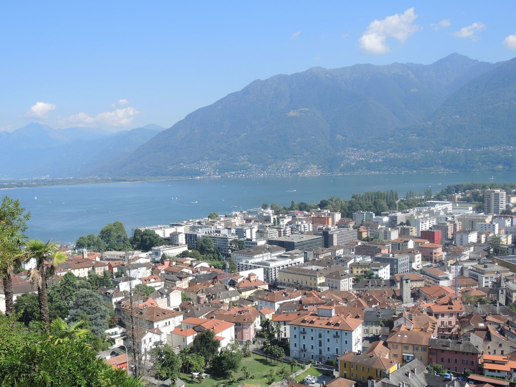 Une ville côtière dotée d’un centre urbain dense, avec une chaîne de montagnes en arrière-plan et un plan d’eau à proximité.