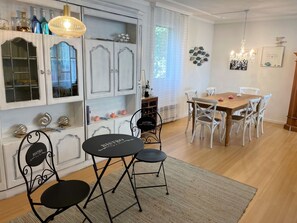 A dining area with a table and chairs, a kitchen with cabinets, and a chandelier. - Dolce Vita by Interhome (Brissago)