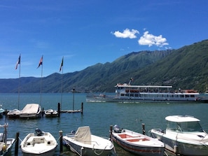 A marina with several boats docked, a large ferry, and mountains in the background. - Residenza Sabrina 10 by Interhome (Ascona)