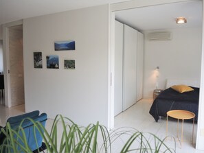 Ein Schlafzimmer mit Bett, Nachttisch, Lampe und Wandklimaanlage.