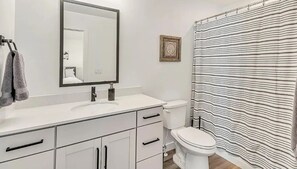 A bathroom with a white sink, mirror, and toilet. There is a towel rack with towels and a framed picture on the wall. - Modern 2 bed townhome just minutes from downtown and SLC airport (Salt Lake City)