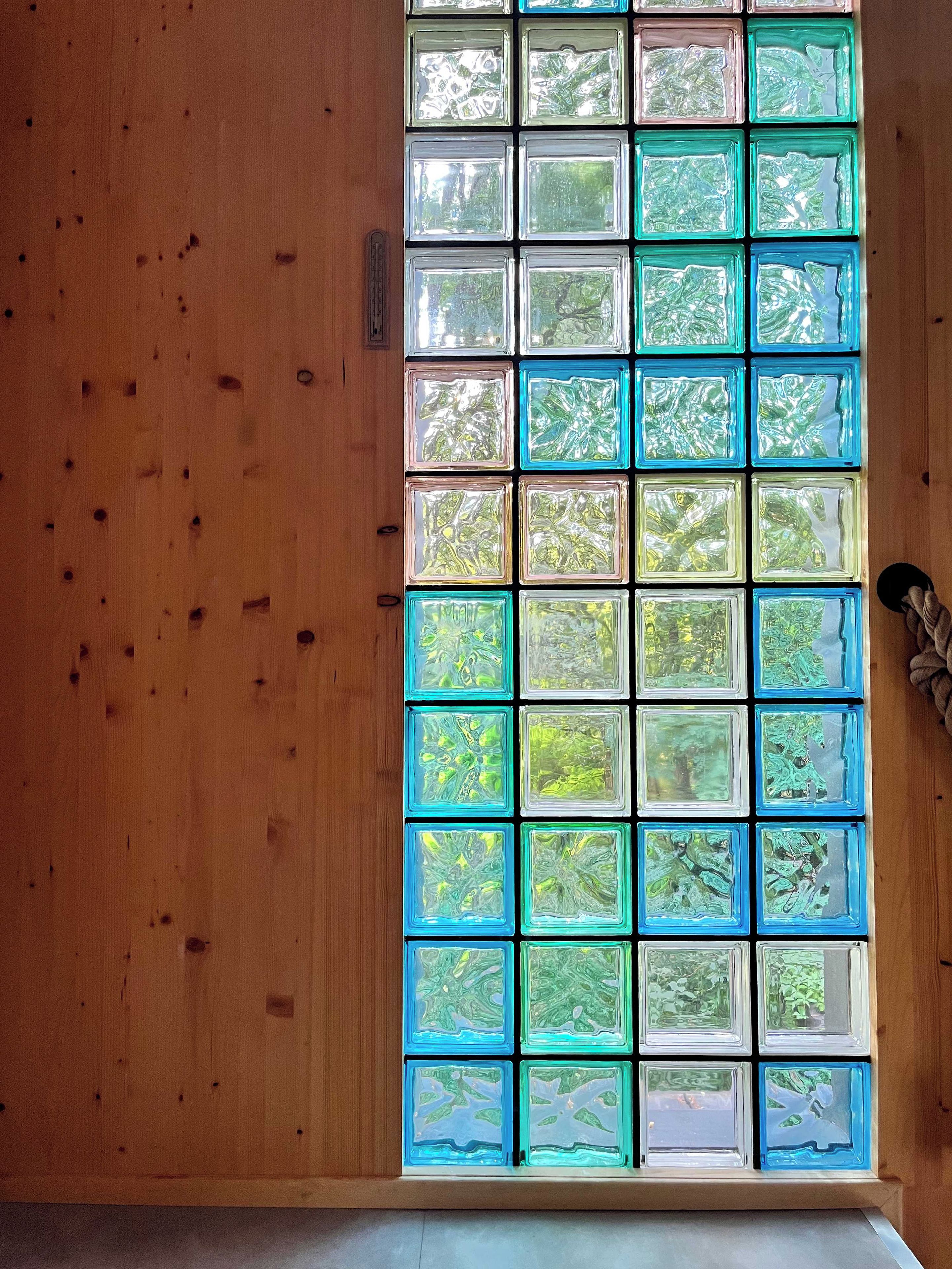 A window with multiple panes, each displaying a different view of greenery.