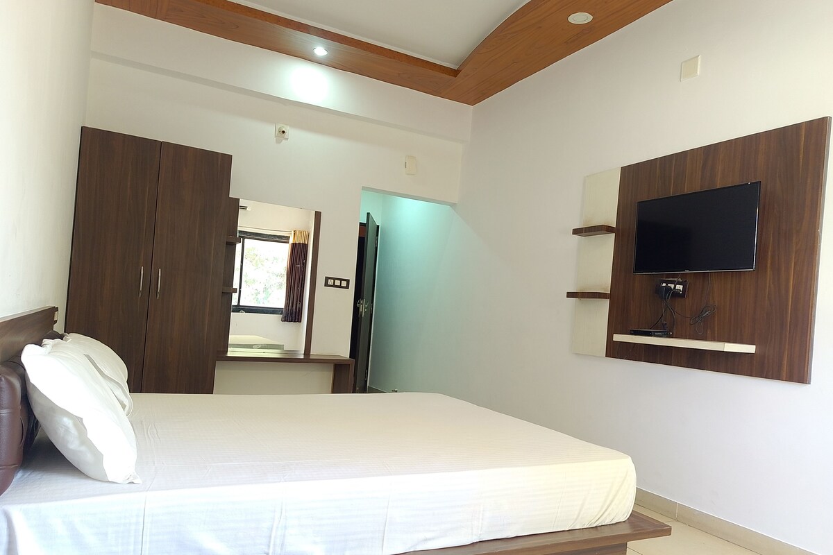 Una camera da letto con un letto, un armadio, uno specchio e una TV a parete.