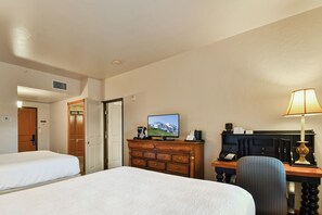 A hotel room with two beds, a desk with a computer, a lamp, and a television displaying a mountainous landscape. - 2BR, 2BA villa with full kitchen in Midway's Zermatt Resort.-2030-2 (Midway)