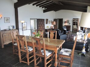 A dining area with a wooden table and chairs, a chandelier, and a view of the outdoors. - La Civetta by Interhome (Brissago)
