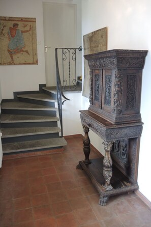 A staircase with a dark wooden finish, a metal railing, and a decorative wooden cabinet with intricate carvings. - La Civetta by Interhome (Brissago)