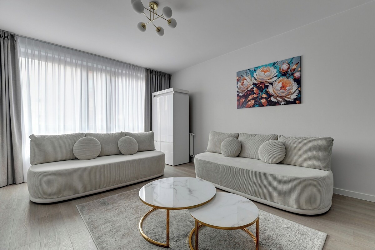 Een moderne woonkamer met twee banken, een salontafel en een schilderij aan de muur.