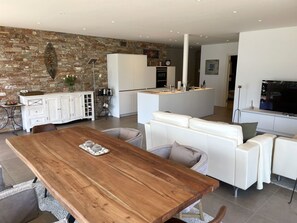 A modern kitchen with white cabinets, a stone wall, and a central island. - Luxury Apartment by Interhome (Minusio)