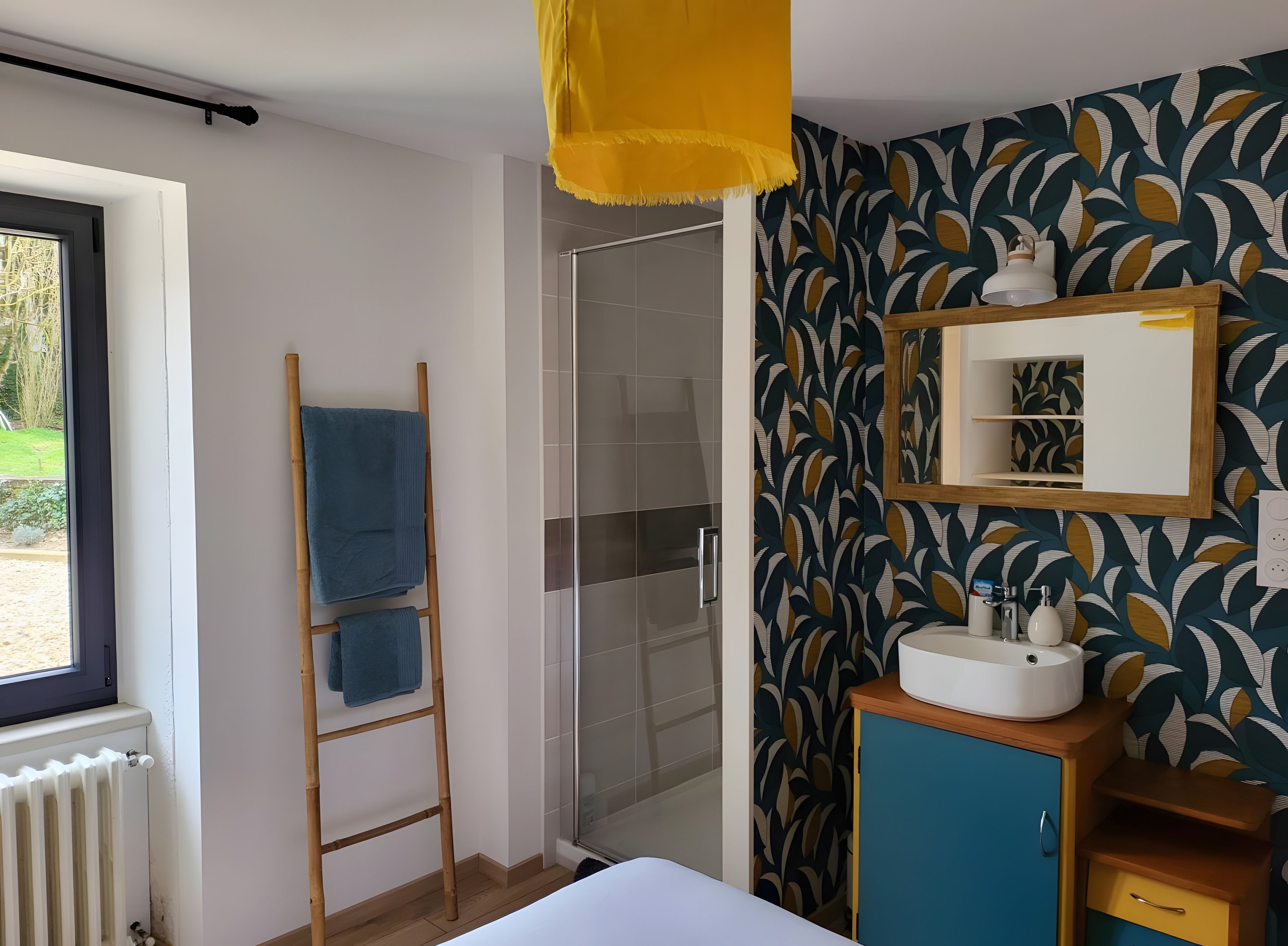 Une chambre d’hôtel avec un lit, une douche, une fenêtre, un porte-serviettes, un miroir et un placard.
