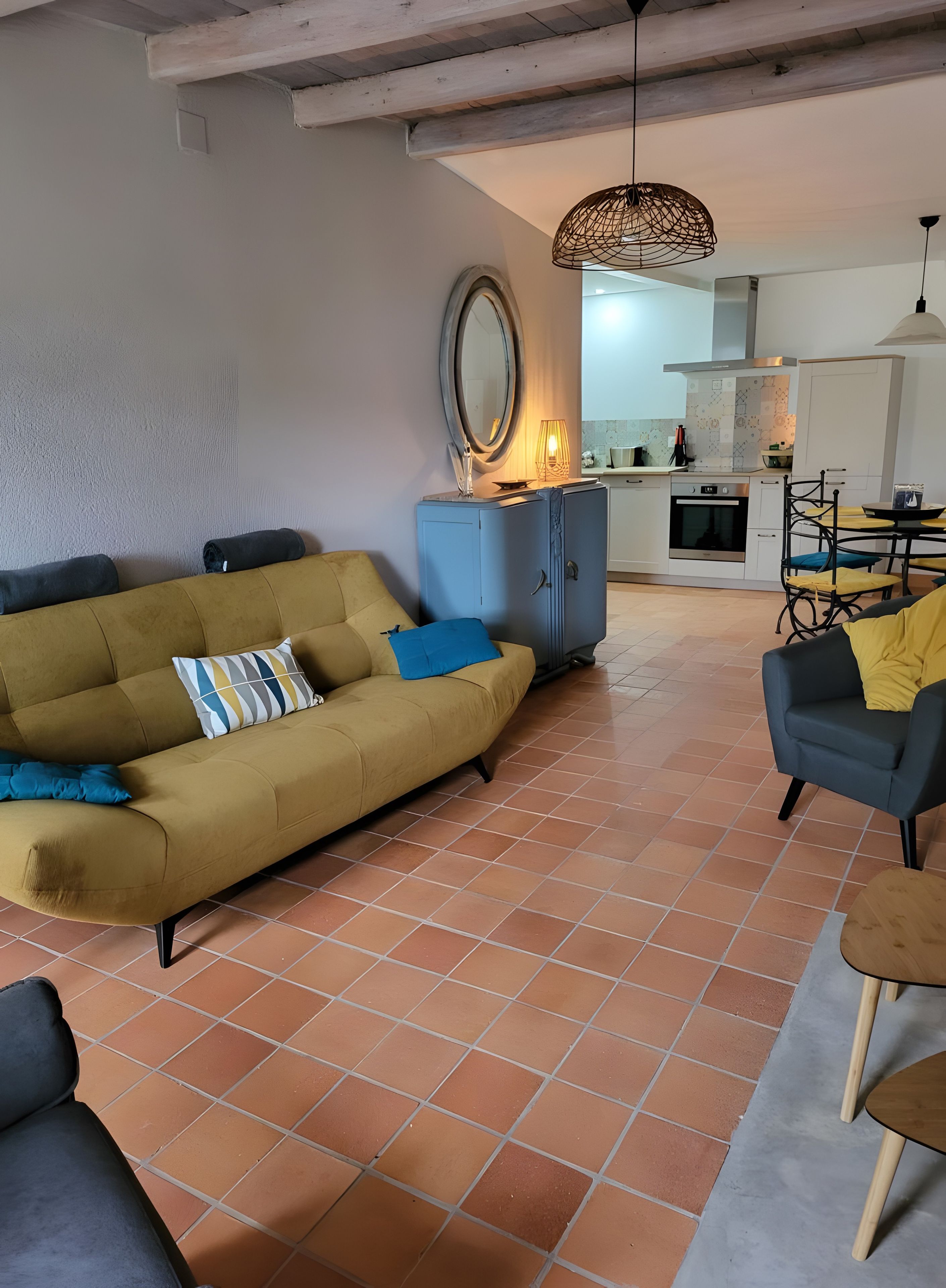 Un salon comprenant un canapé, une table basse et un coin repas avec des chaises.