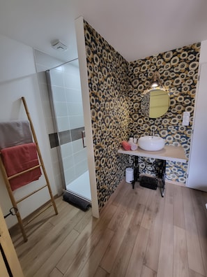 Ein Badezimmer mit Dusche, Waschbecken und Spiegel.