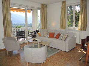 A living room with a sofa, chairs, a small table, and a piano. - Villa Dora Garten by Interhome (Locarno)