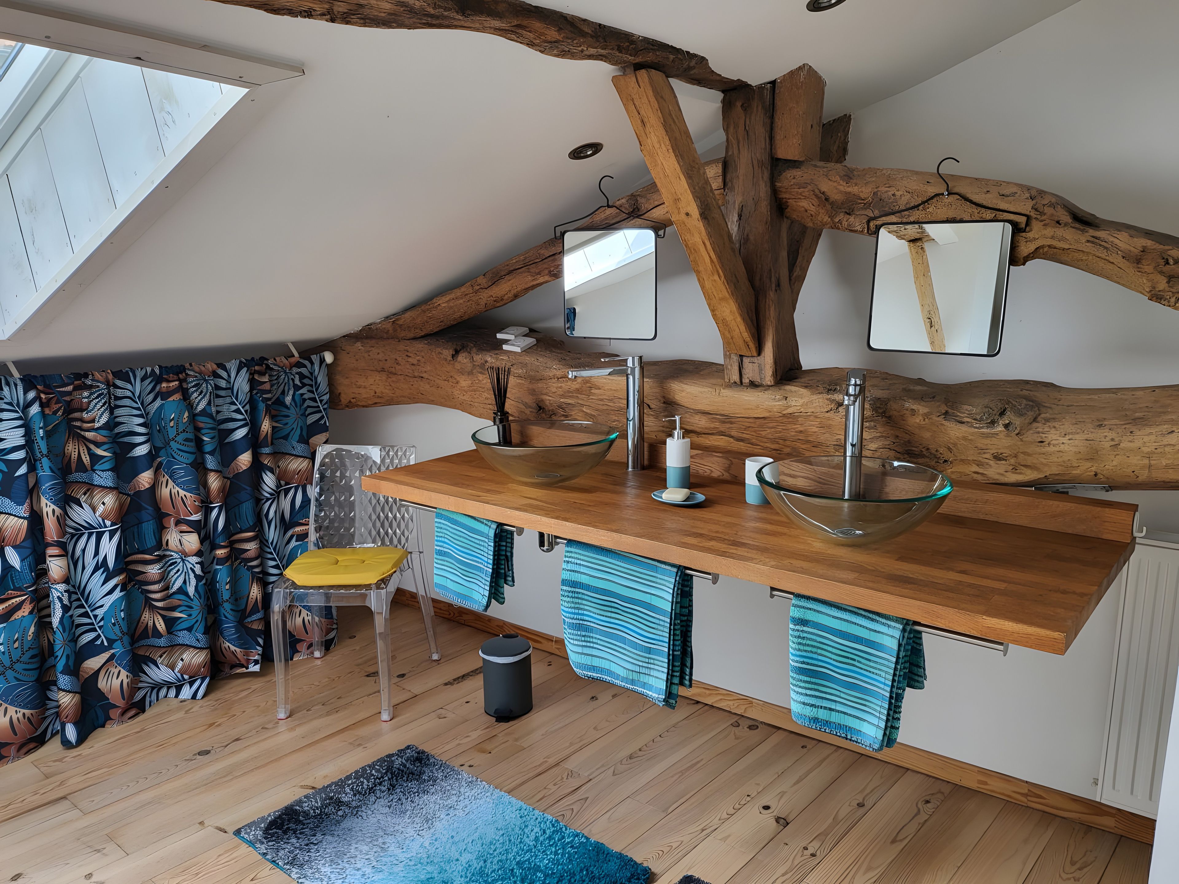 Een moderne keuken met een houten plafond, twee grote glazen schalen op een houten aanrecht, een gele stoel en een raam met gordijnen.