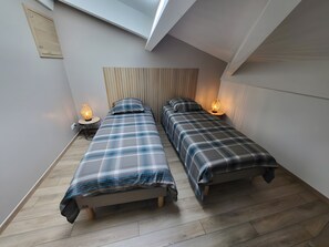 A small, modern bedroom with two beds, a sloped ceiling, and a skylight. - Cottage 'Gîte 3 Étoiles Climatisée La Mezza' with Shared Pool, Wi-Fi and Air Conditioning (Mareuil)