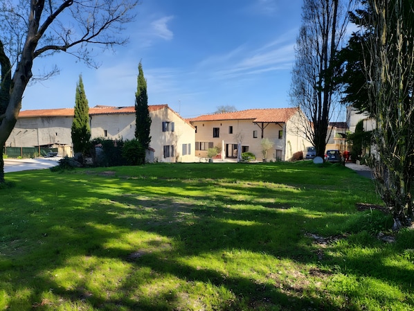 Un quartiere residenziale con case, un prato verde e cielo sereno.