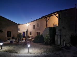 Un cortile con posti a sedere all'aperto, una pergola e una zona ben illuminata.