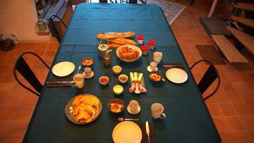 A dining table set with various dishes and utensils, surrounded by chairs.
