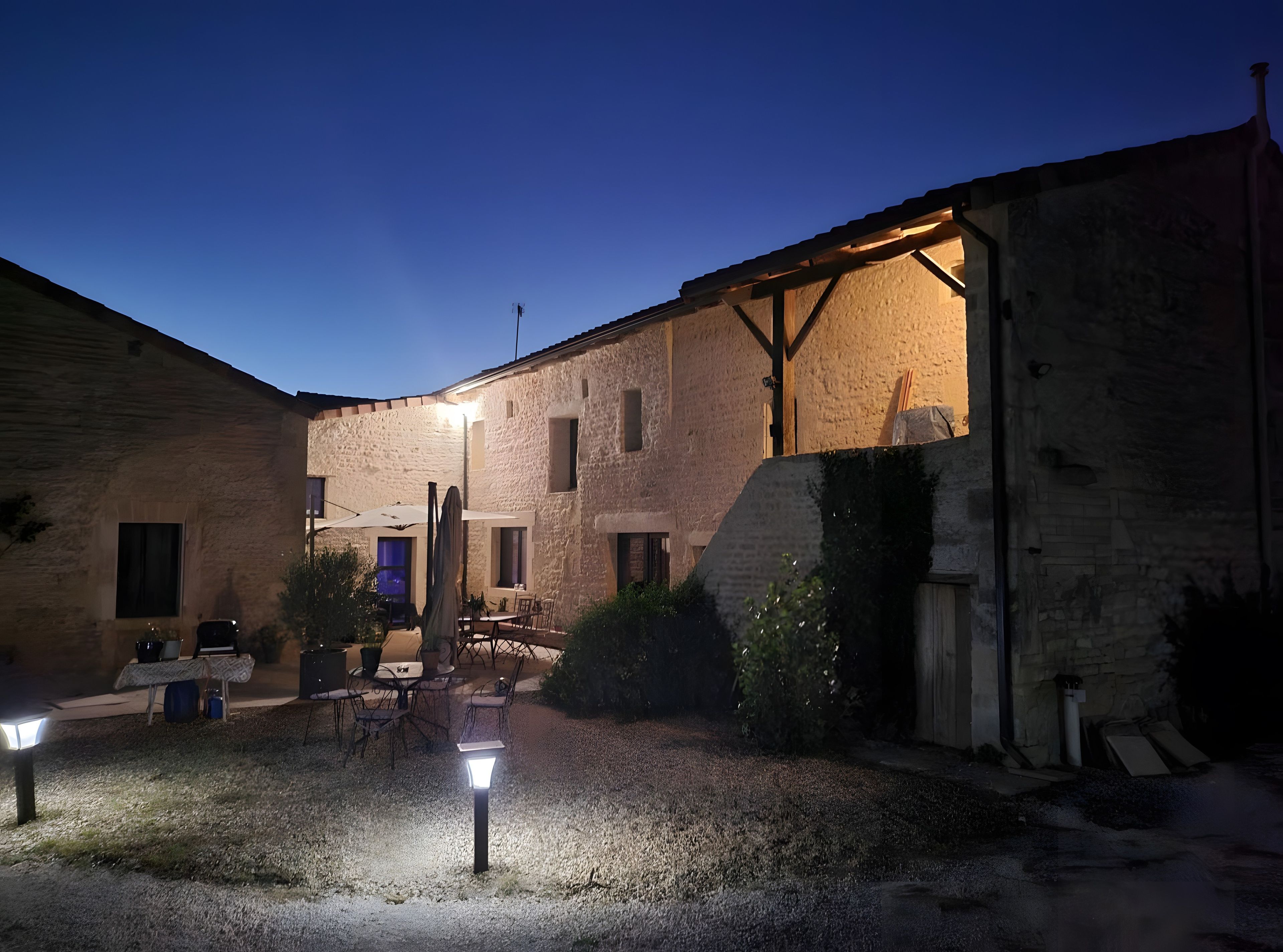 Une cour avec des sièges extérieurs, une pergola et un espace bien éclairé.