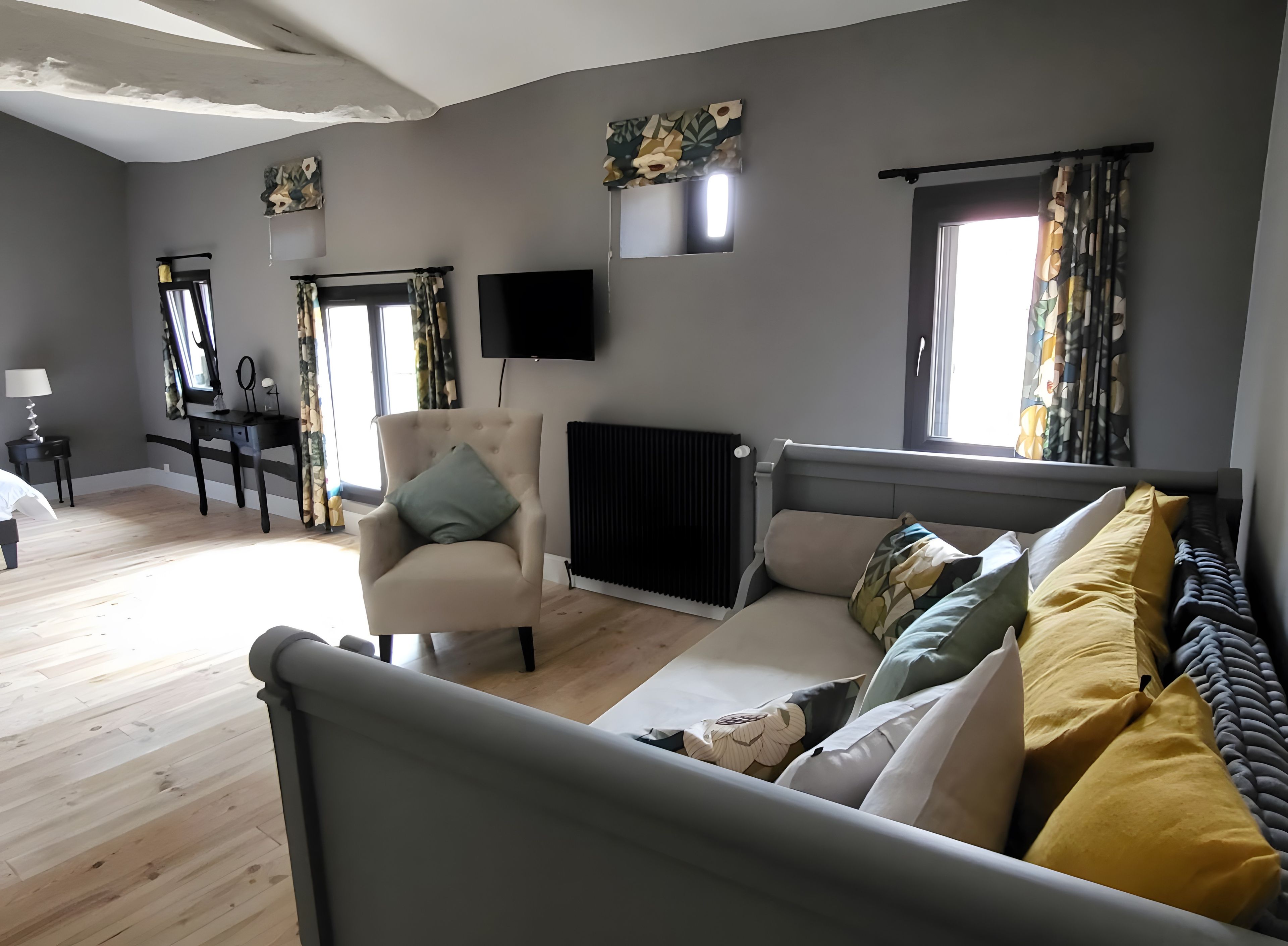 Une chambre à coucher moderne, avec un lit, une chaise, un bureau et un radiateur.