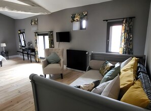 A modern bedroom with a bed, a chair, a desk, and a radiator.