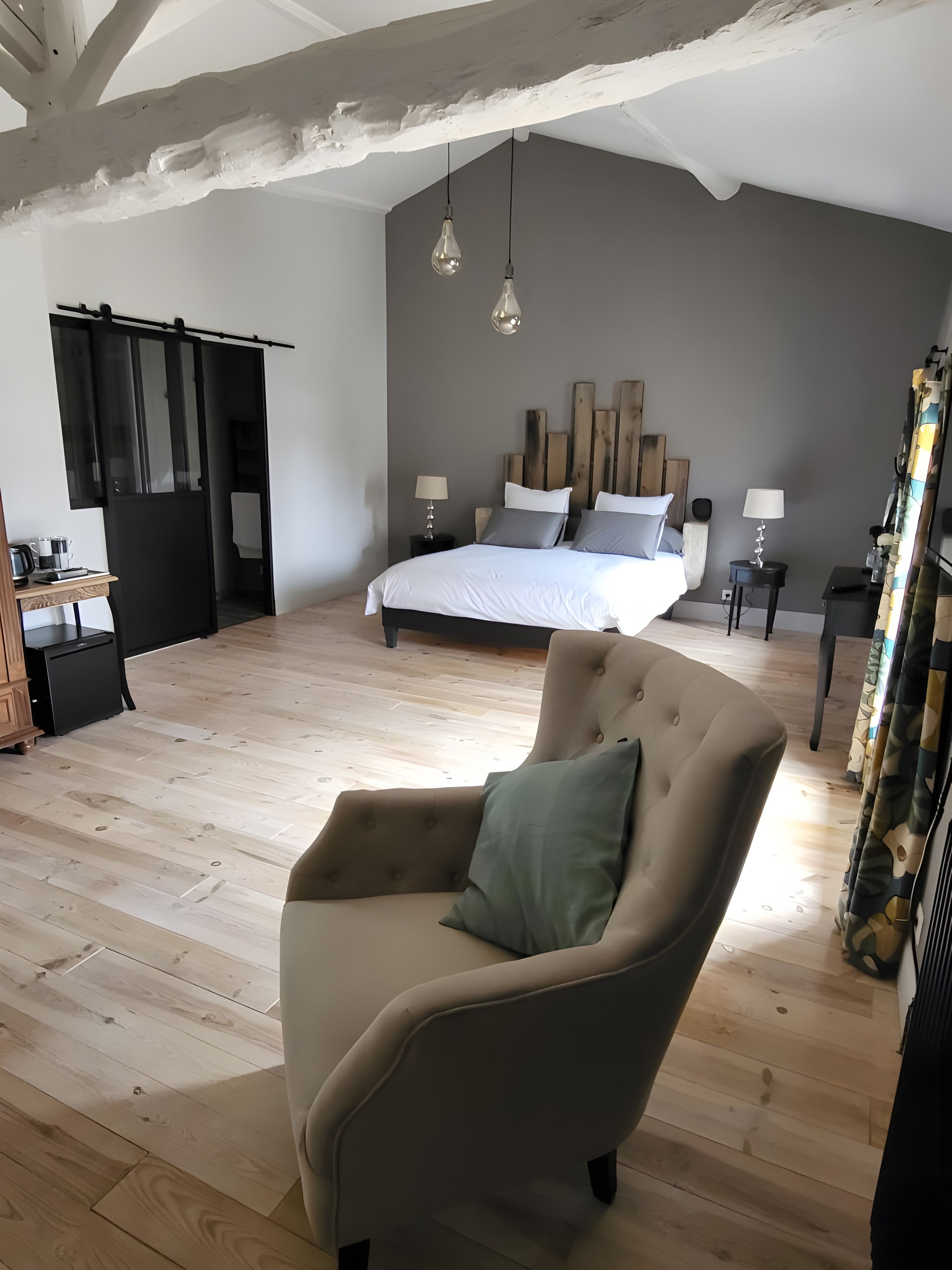 Une chambre à coucher avec un lit, des tables de chevet, une chaise et un plafond en bois.