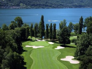 A golf course with sand bunkers and a lake in the background. - La Quercia by Interhome (Ascona)