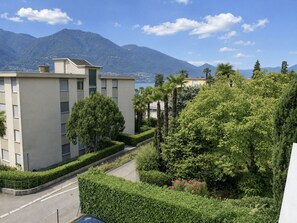A residential area with modern buildings, a well-maintained garden, and a mountain backdrop. - Belinda by Interhome (Minusio)