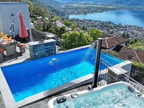 A rooftop infinity pool with a view of a lake and town. - Casa Makatea by Interhome (Brione sopra Minusio)