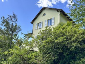 A two-story building with a light-colored facade, white shutters, and a visible balcony. - Villa Grande Dame by Interhome (Minusio)