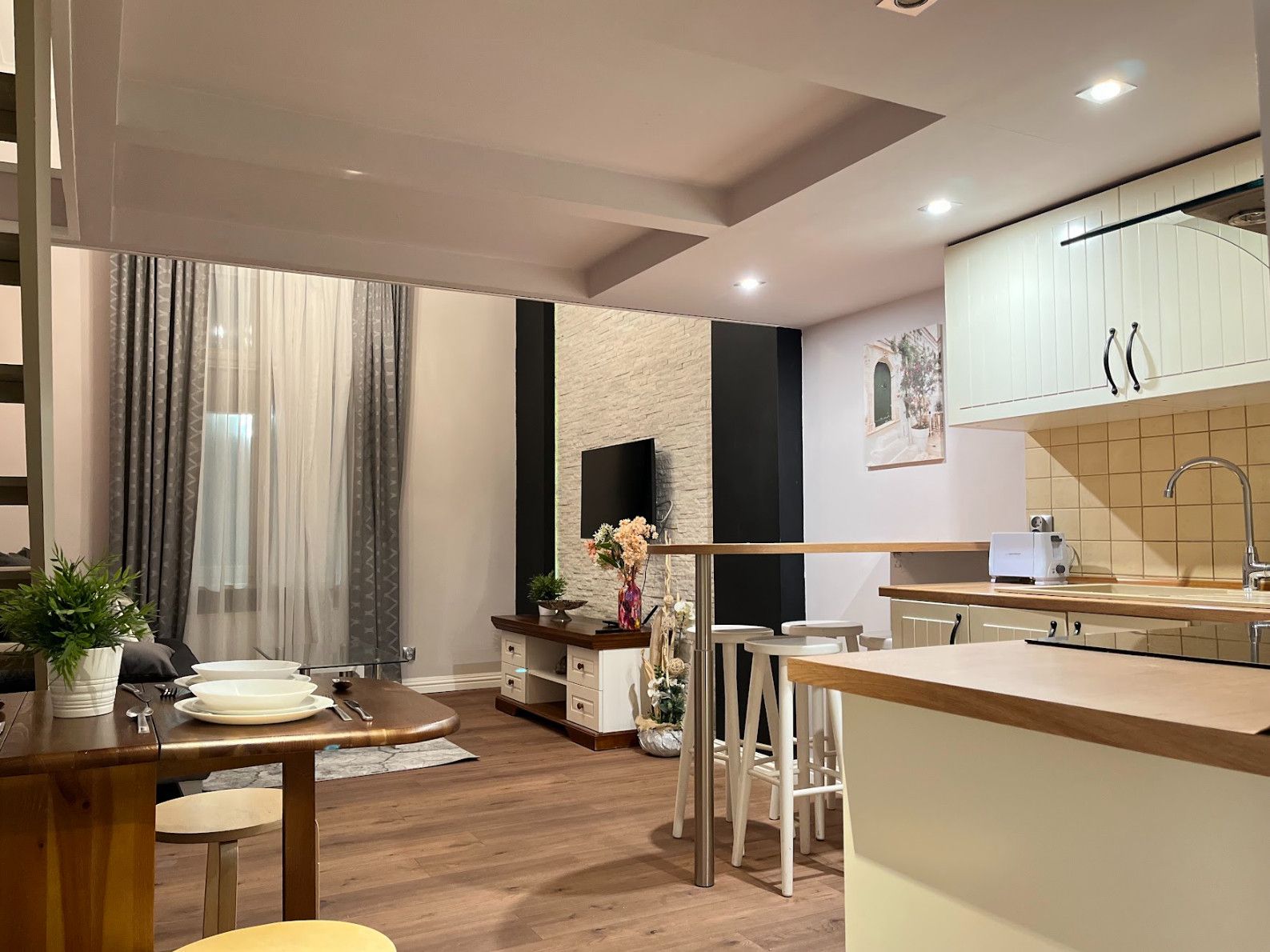 A modern kitchen with white cabinets, a built-in oven, and a sink.