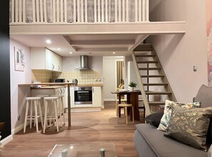 A modern apartment with a kitchen, dining area, and a staircase leading to an upper level. - Apartment for 8 guests in Jewish Disctrict Cracow, Bożego Ciała (Kraków)