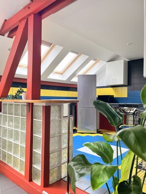 A room with a skylight, red structural beams, a glass partition, and a plant. - Spacious Apartment for 12 guest in Cracow Old Town, Sarego (Kraków)