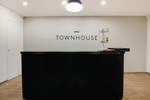En receptionsdisk med en skylt där det står ”TOWNHOUSE” och en vattenautomat ovanpå.