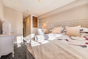 A hotel room with a bed, bedside table, and a wardrobe. - Dual En-Suite 2-Bed · Sleeps 4 · Walk to Whitby Harbour & Abbey (North Yorkshire)