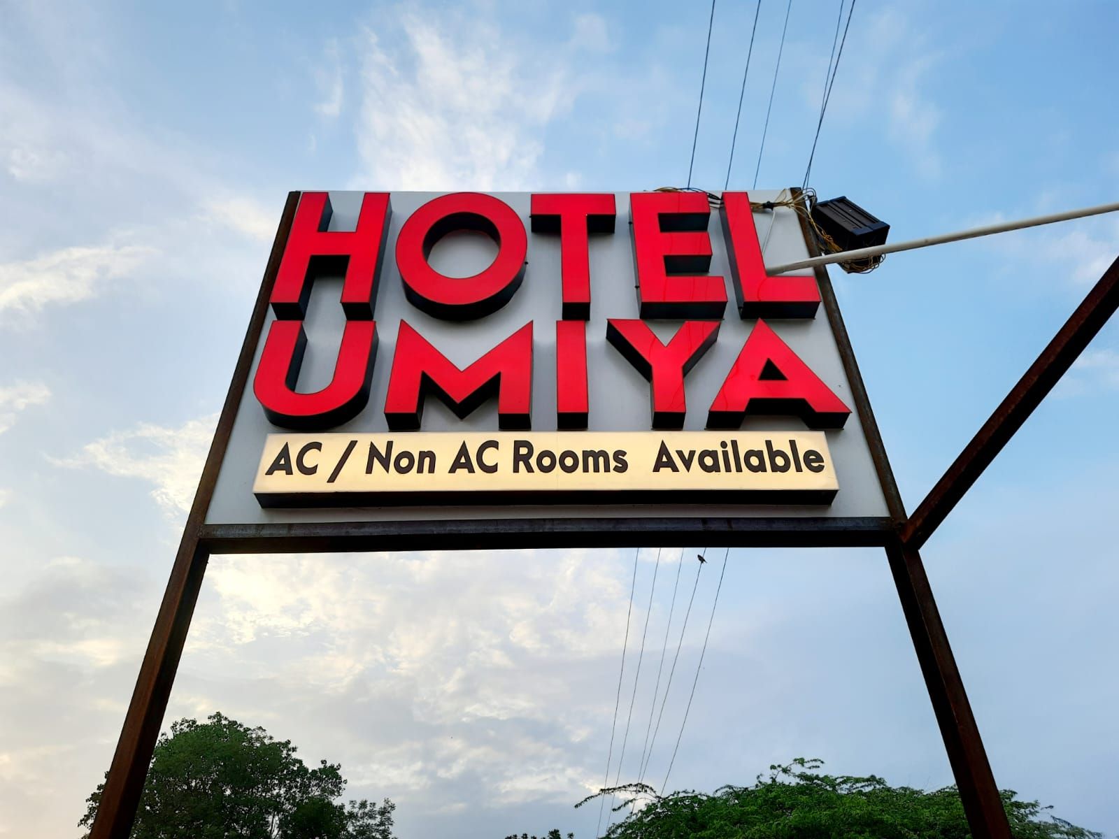 Placa indicando HOTEL UMIYA, com quartos com ar condicionado e sem ar condicionado.