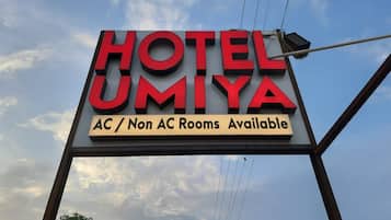 A hotel sign with 'HOTEL UMIYA' and 'AC / Non AC Rooms Available' text.