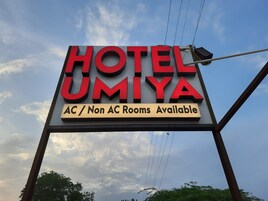 A hotel sign with 'HOTEL UMIYA' and 'AC / Non AC Rooms Available' text.