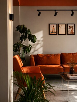 A modern living room with a sofa, a coffee table, and a large plant.