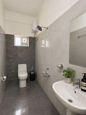 A modern bathroom with a toilet, bidet, and sink. - Manzl Collective - Palm (Tada Khandrika)