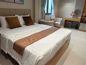Une chambre à coucher moderne avec un grand lit, un bureau et une chaise.