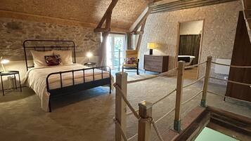 Een knus zolderkamer met een bed, een tafeltje en een stoel.