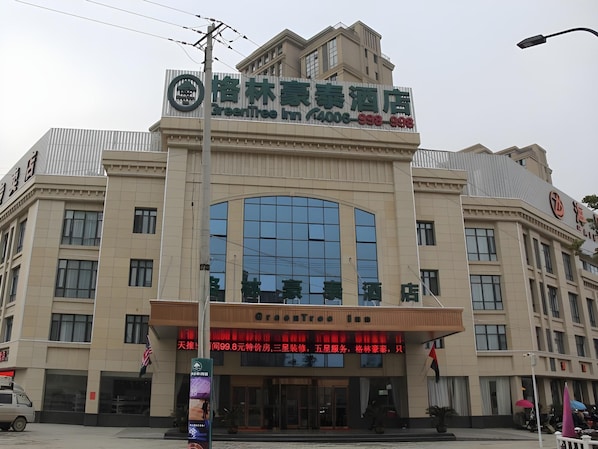 A hotel with a prominent green and white sign, large windows, and a digital display at the entrance. - Greentree Inn Fuyang Yingshang Yingyang Road Suzhou Manor Hotel (Fuyang)
