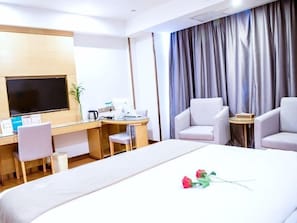 A hotel room with a bed, a desk, a chair, a television, and a curtain. - Greentree Inn Fuyang Yingshang Yingyang Road Suzhou Manor Hotel (Fuyang)