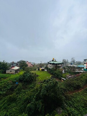 Una zona residencial con casas, un campo verde y cielo nublado.