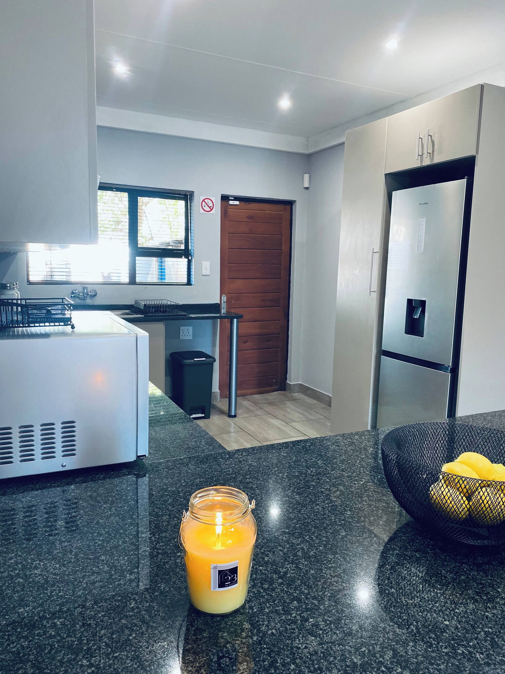 A modern kitchen with a refrigerator, a sink, and a window.