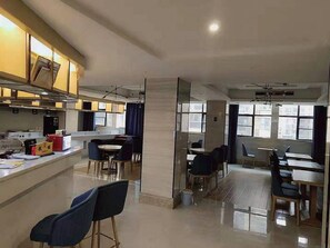 A modern hotel lobby with a central seating area, a reception desk, and a view of the city through large windows. - Kyriad Marvelous Hotel (Yiyang)