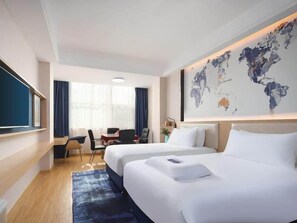 A hotel room with two beds, a desk, a chair, a world map on the wall, and a large window. - Kyriad Marvelous Hotel (Yiyang)