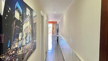 A hallway with a cityscape mural on the left and a white wall on the right.