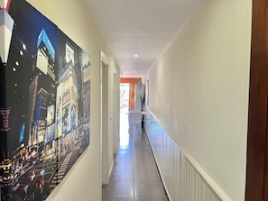 A hallway with a cityscape mural on the left and a white wall on the right. - Apartment 'Neptuno Pool&Beach By Sydney' with Communal Pool, Private Terrace and Wi-Fi (La Arena)